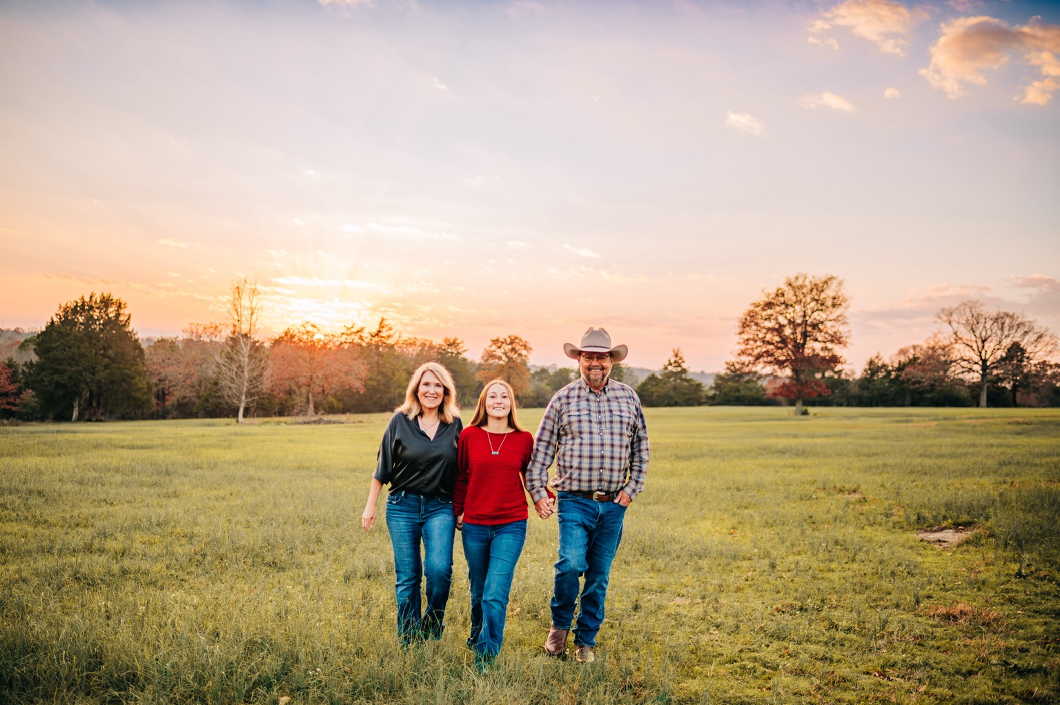The Capps family in a wide pasture at sunset