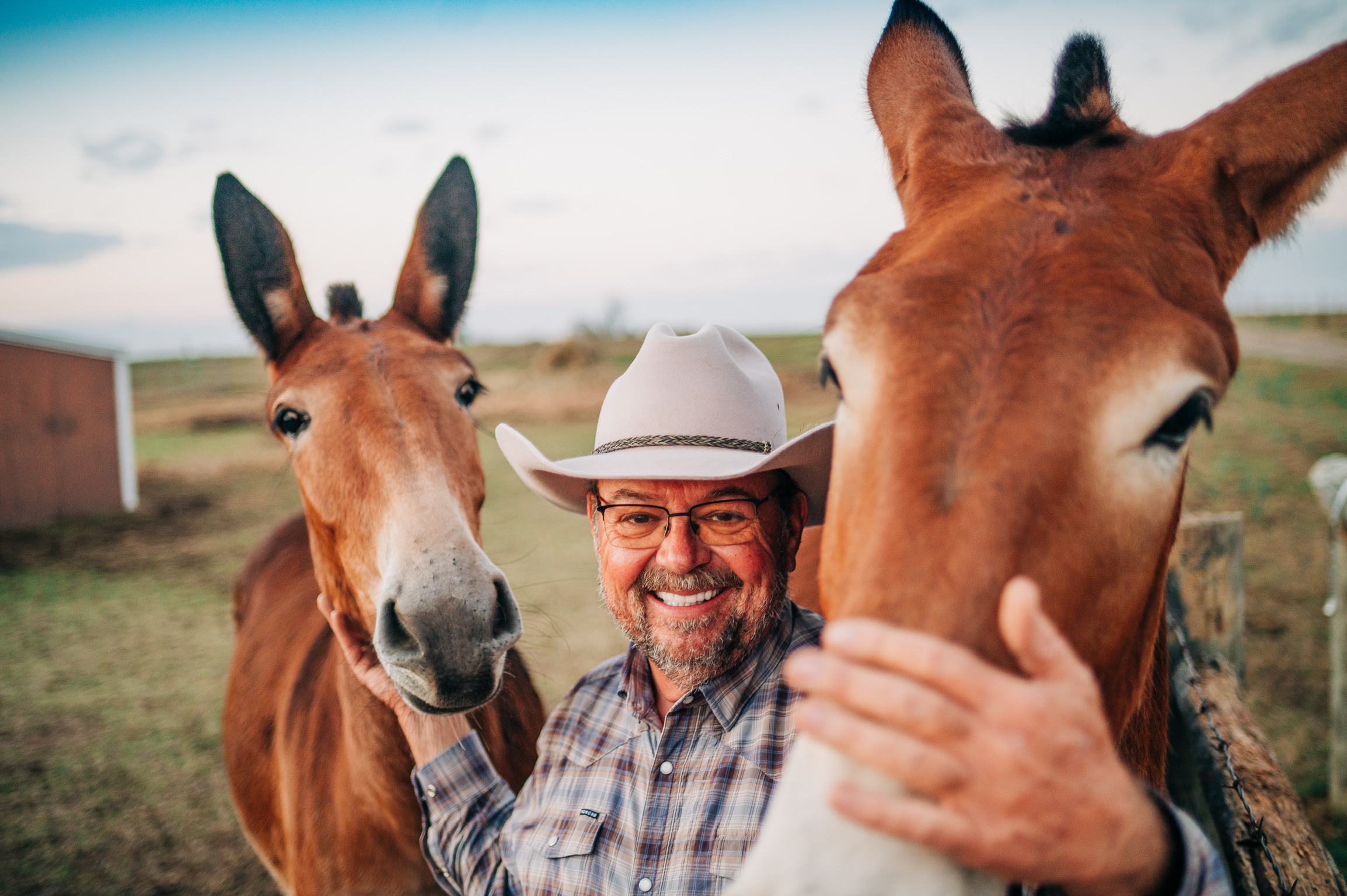 Keith smiling between two of the farm’s animals